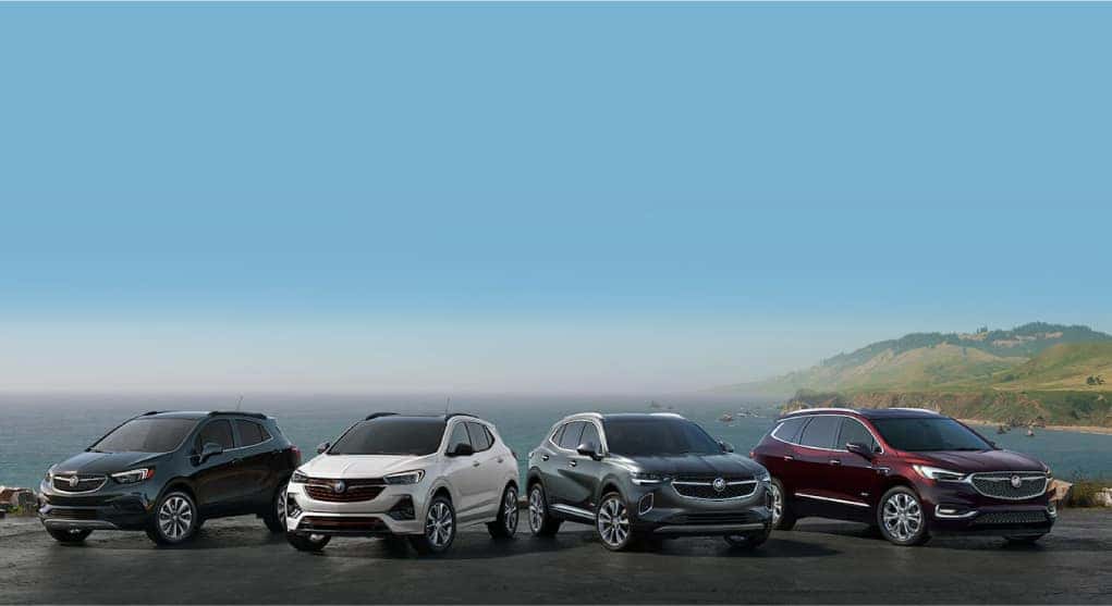 Four Buick-GMC vehicles, shown from the front, overlooking ocean cliffs