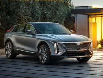 The Cadillac LYRIQ, shown from the front, in front of a modern house