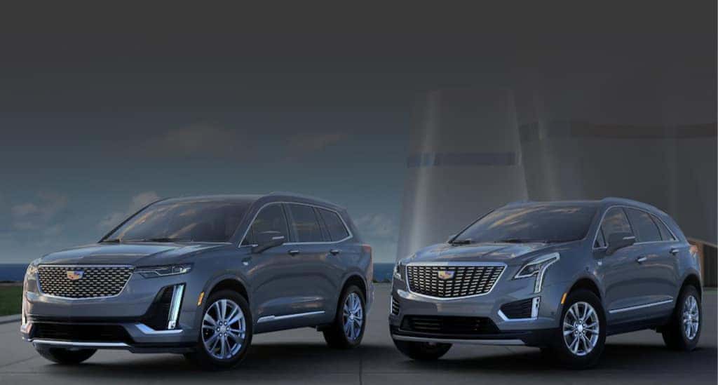 Two Cadillac vehicles, parked on an angle, overlooking the coast line