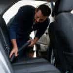 Man vacuuming the vehicle interior