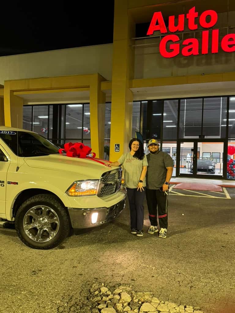 Customers celebrating a Ram pickup delivery at Auto Gallery