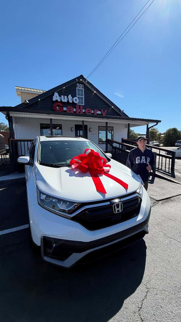 Customer beside a white Honda SUV at Auto Gallery