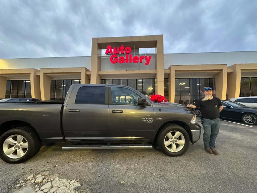 Customer beside a Ram pickup outside Auto Gallery