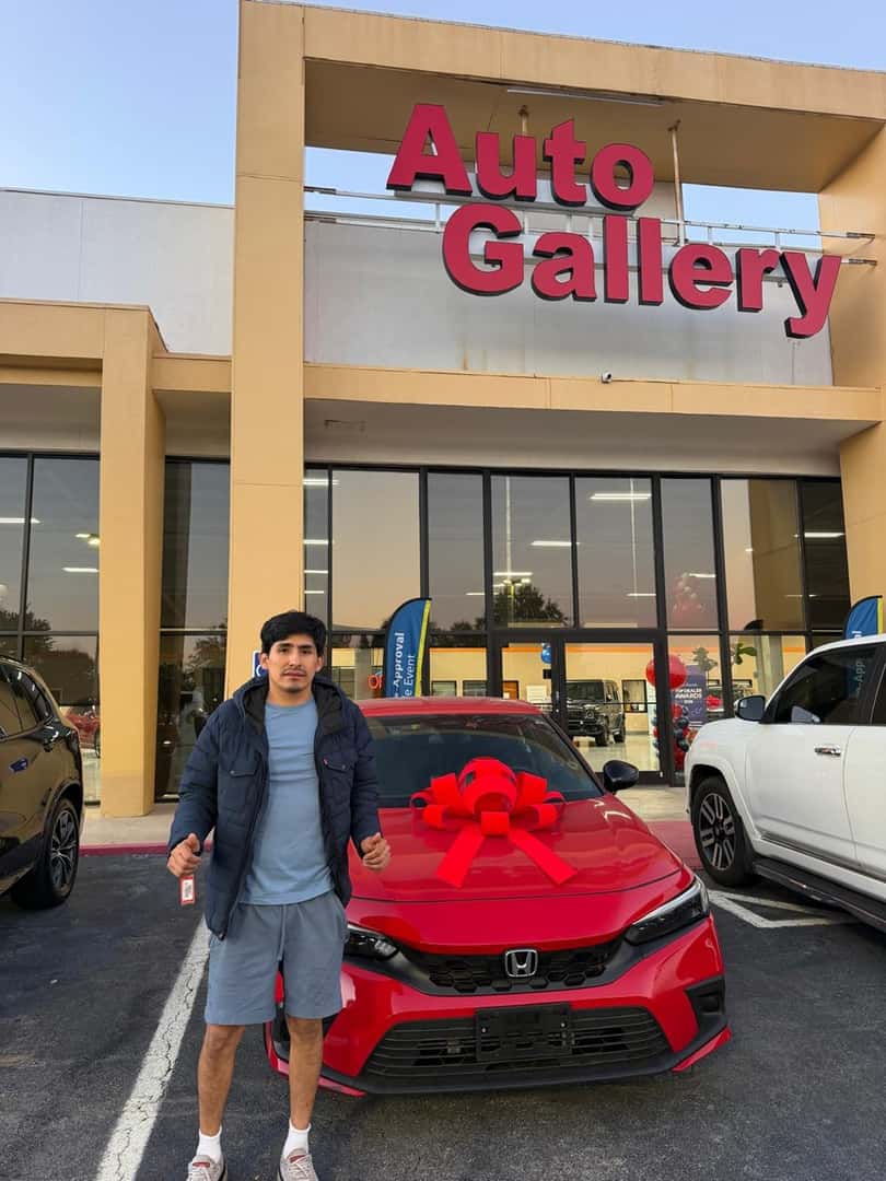 Customer beside a red Honda at Auto Gallery