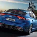 Blue Kia Stinger Driving Towards City