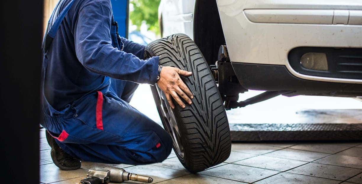 Man Putting Tire on Car