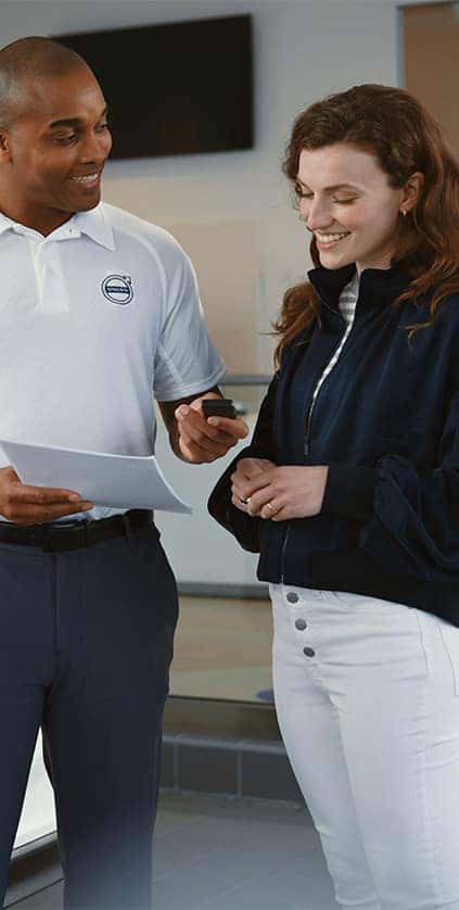 Leasing versus Buying a Volvo at Delaney Volvo Cars Greensburg in Greensburg, PA | Volvo sales person handing over new car keys and paper work to client
