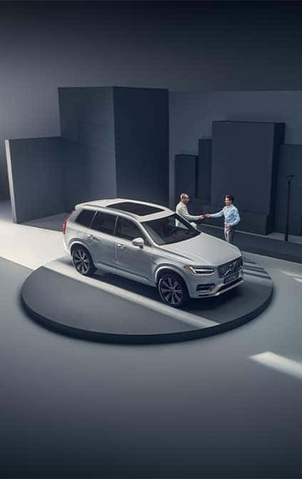 Leasing versus Buying a Volvo at Delaney Volvo Cars Greensburg in Greensburg, PA | Sales person shaking hands with client behind a XC 90