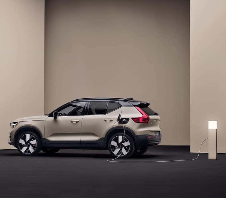 2025 Volvo EX40 | Side profile of a 2025 Volvo EX40 charging near a charging dock