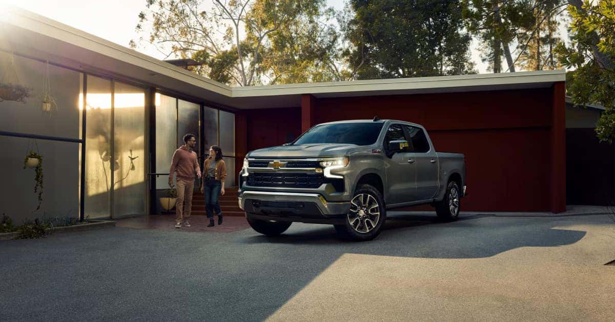 2025-Chevy-Silverado-1500-parked-in-a-driveway-while-a-couple-walks-beside-it