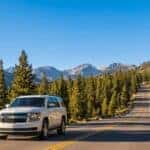 White Chevrolet Tahoe driving uphill on I-80 Sierra Nevada mountain grade summer Auburn California