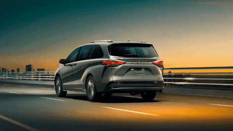 2023 Toyota Minivans driving on an urban road at night