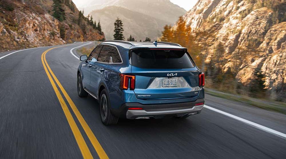 blue 2025 Kia Sorento Hybrid driving on mountain roads