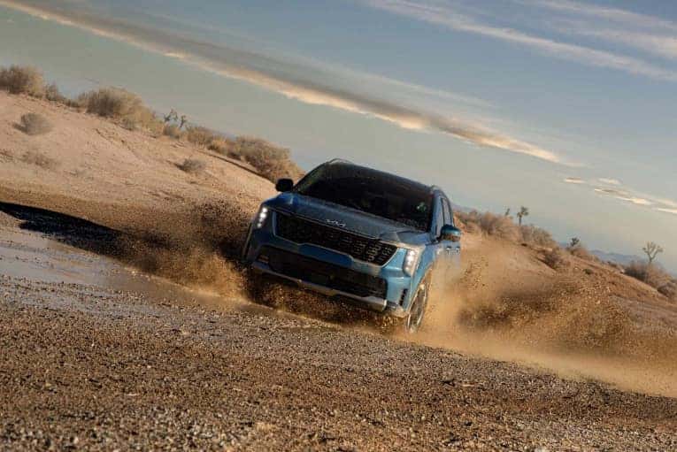 blue 2025 Kia Sorento Hybrid driving in mud