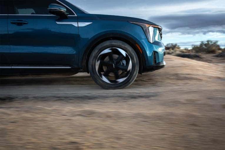 side view of blue 2025 Kia Sorento Hybrid driving