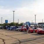 Car Show Lineup with Dealership in Background