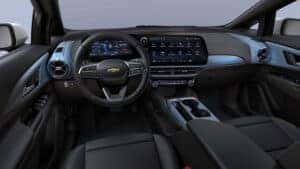 Chevy Equinox EV black interior with steering wheel, display screen, two front seats, and cupholders