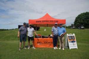 Four men in front of Jeff Belzer tent 
