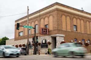 Front exterior of Jax Cafe with cars passing by 