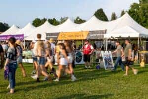 People walking past the Jeff Belzer tent at Lakefront