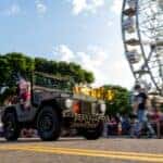 Green truck at car cruise with ferris wheel in the background
