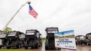 thank you 5 star sponsor board with golf karts and an american flag