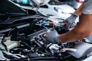 mechanic working on engine of vehicle