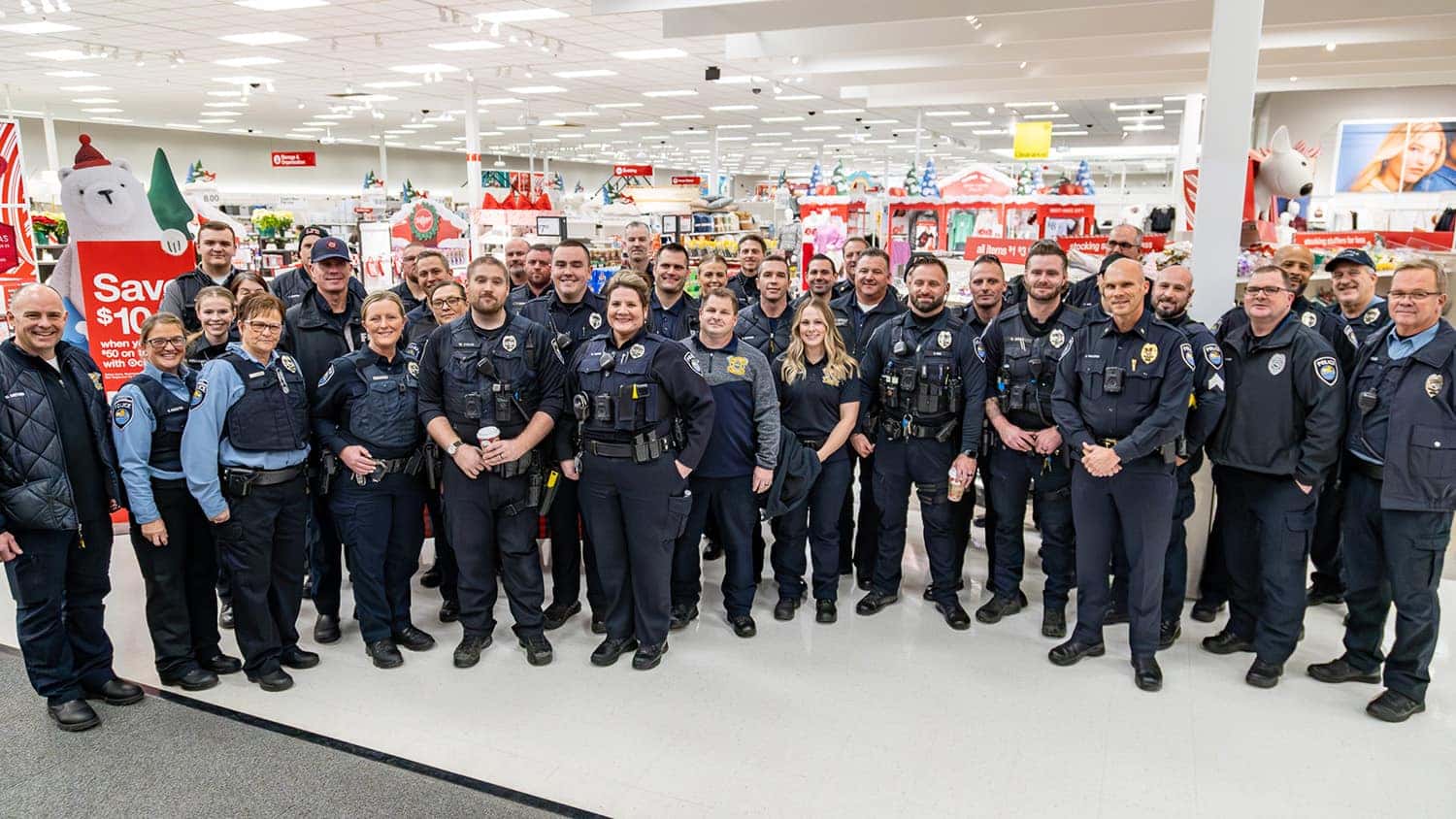 group photo of fire fighters and law enforcement at Shop with a Hero event