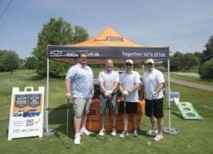 group of golfers in front of Jeff Belzer's tent