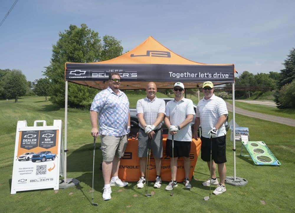 group of golfers in front of Jeff Belzer's tent
