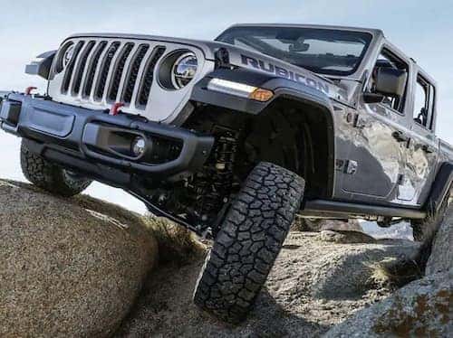 2023 Jeep Gladiator close up view driving over large rocks