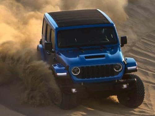 2024 Jeep Wrangler driving fast through sand
