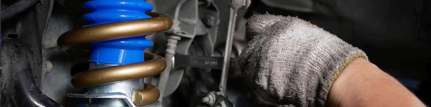 Close up view of a service tech checking out a vehicle's suspension