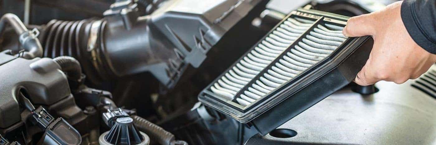 Close up view of a service tech changing out an engine's air filter