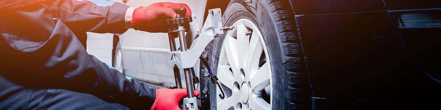 close up view of a service tech aligning a vehicle's wheel
