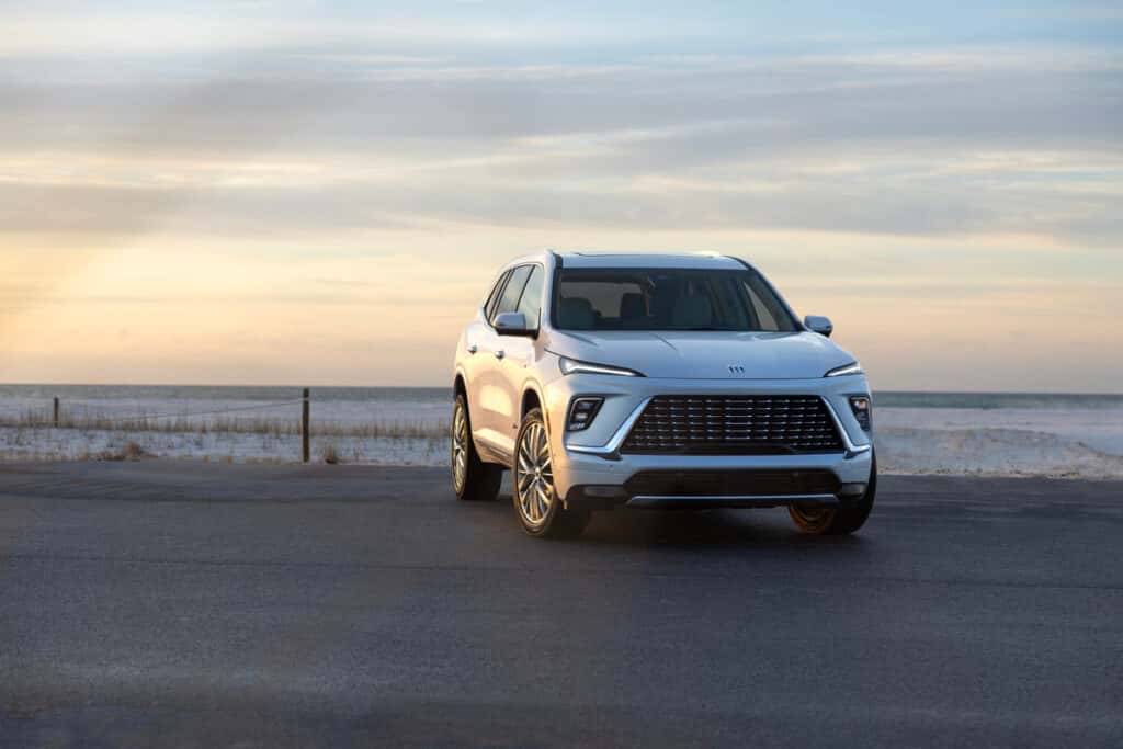 Front and side view of the 2025 Buick Enclave driving through city