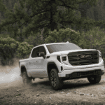 Front view of the 2025 GMC Sierra 1500 AT4 driving off-road
