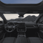 Spacious and modern 2026 GMC Acadia Denali interior featuring the 15-inch vertical infotainment screen and premium leather seating.