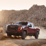 A 2026 GMC Sierra HD pickup truck in the new Coastal Dune paint color parked near the coast in Vero Beach, Florida.
