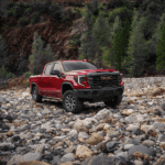 A sophisticated 2026 GMC Sierra 1500 Denali Ultimate parked near a scenic Vero Beach coastline, highlighting its bold design.