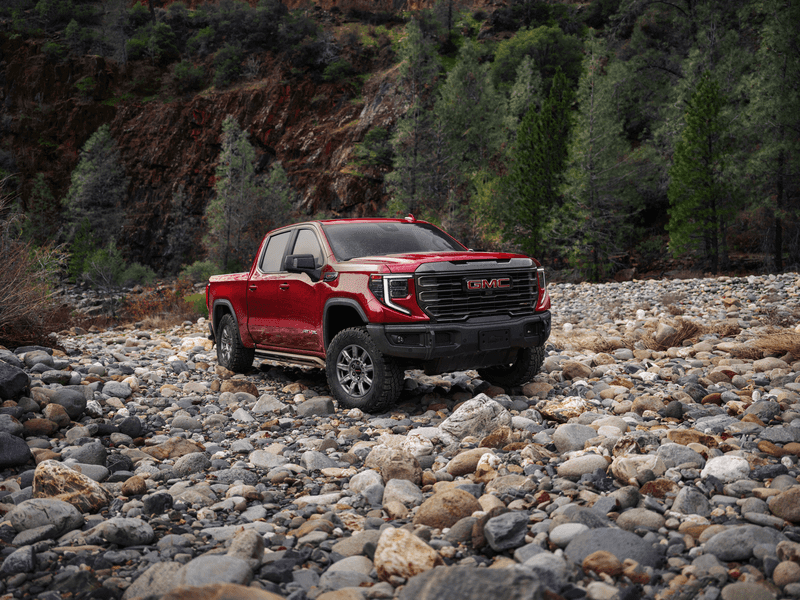 A sophisticated 2026 GMC Sierra 1500 Denali Ultimate parked near a scenic Vero Beach coastline, highlighting its bold design.