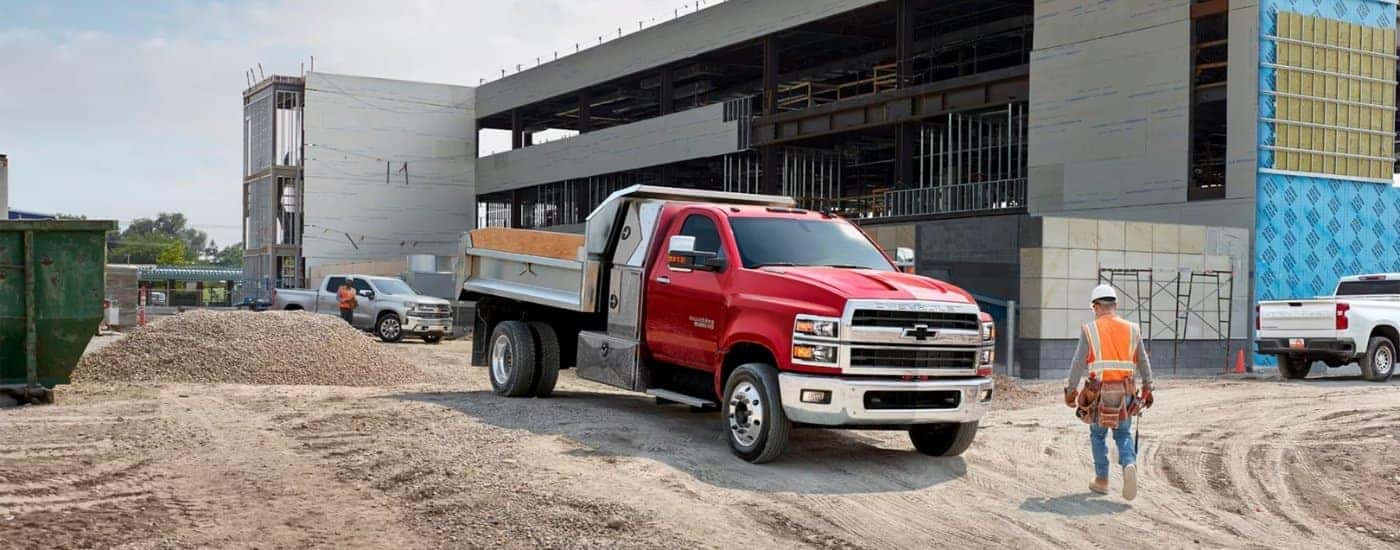A red 2024 Chevy Silverado 5500 HD driving through a construction site.