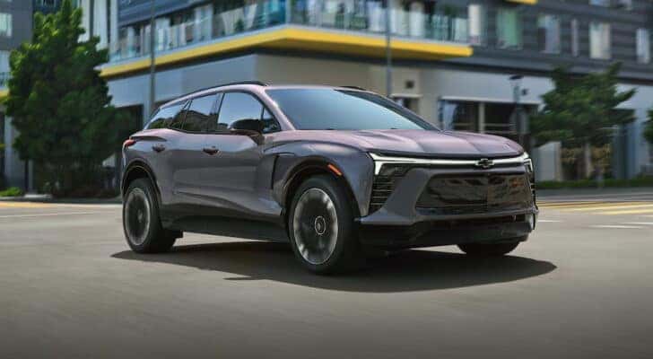 A grey 2025 Chevy Blazer EV for sale driving through a city.