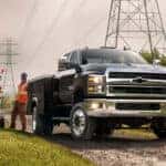 A black 2024 Chevy Silverado 6500 for sale is shown near power lines.
