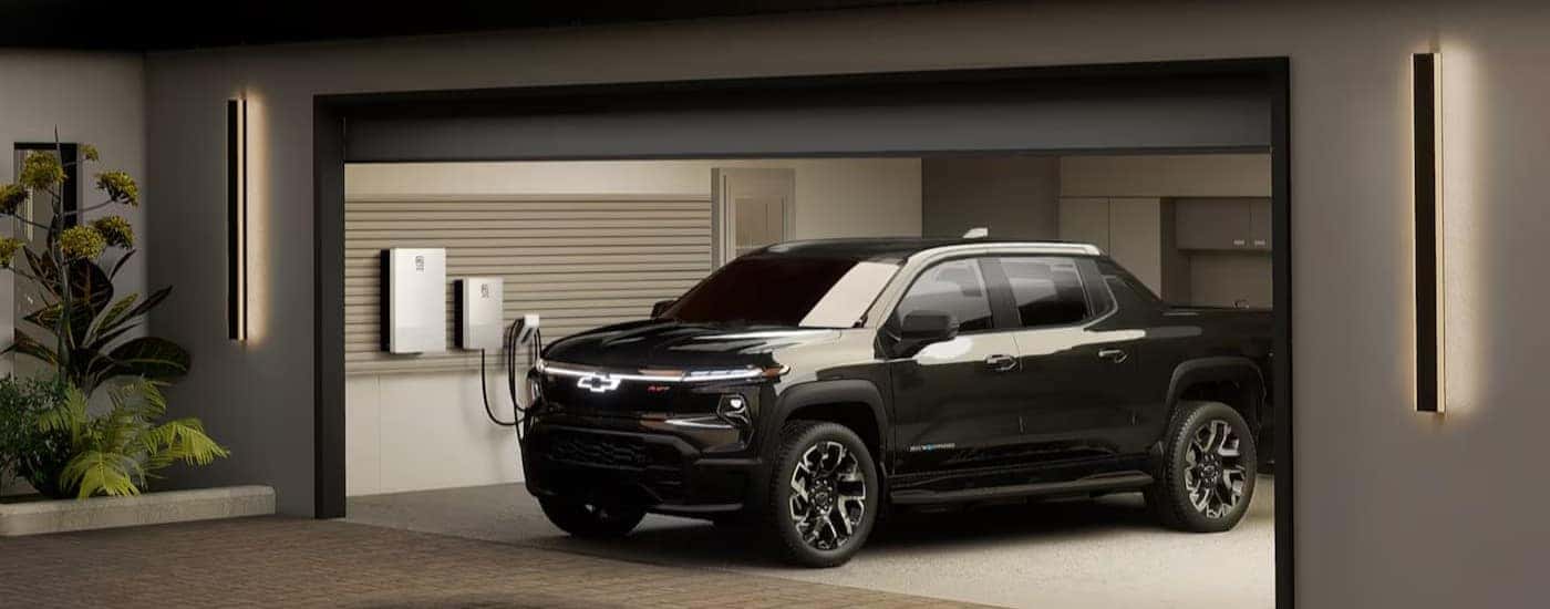 A black 2024 Chevy Silverado EV RST is shown parked in a garage.