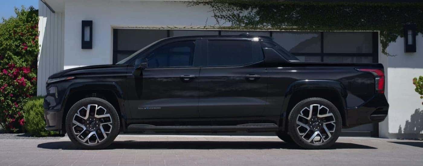 A black 2025 Chevy Silverado EV is shown parked on a driveway.