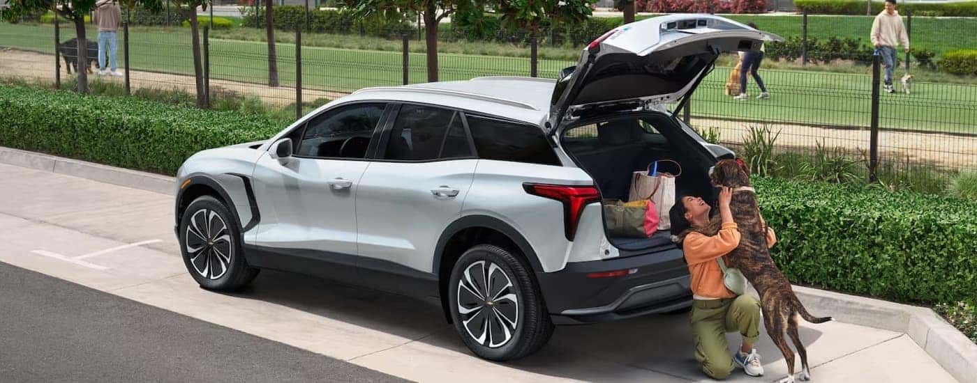 A family is sitting on the rear of a white 2025 Chevy Blazer EV.