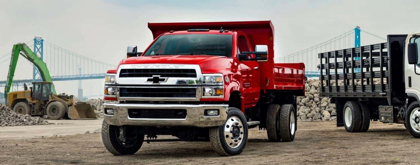 A red 2025 Chevy Silverado 5500 HD parked near a construction site.
