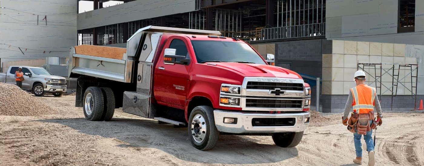 A red 2025 Chevy Silverado 5500 driving around a construction site.
