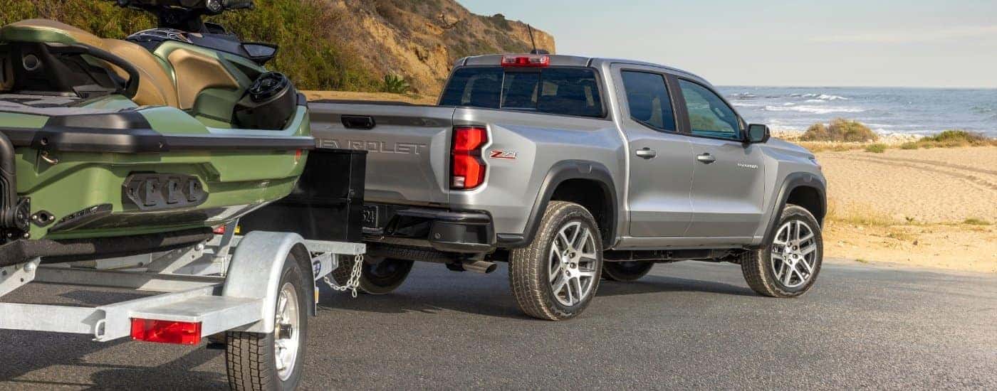 A silver 2023 Chevy Colorado from the rear towing a jetski.